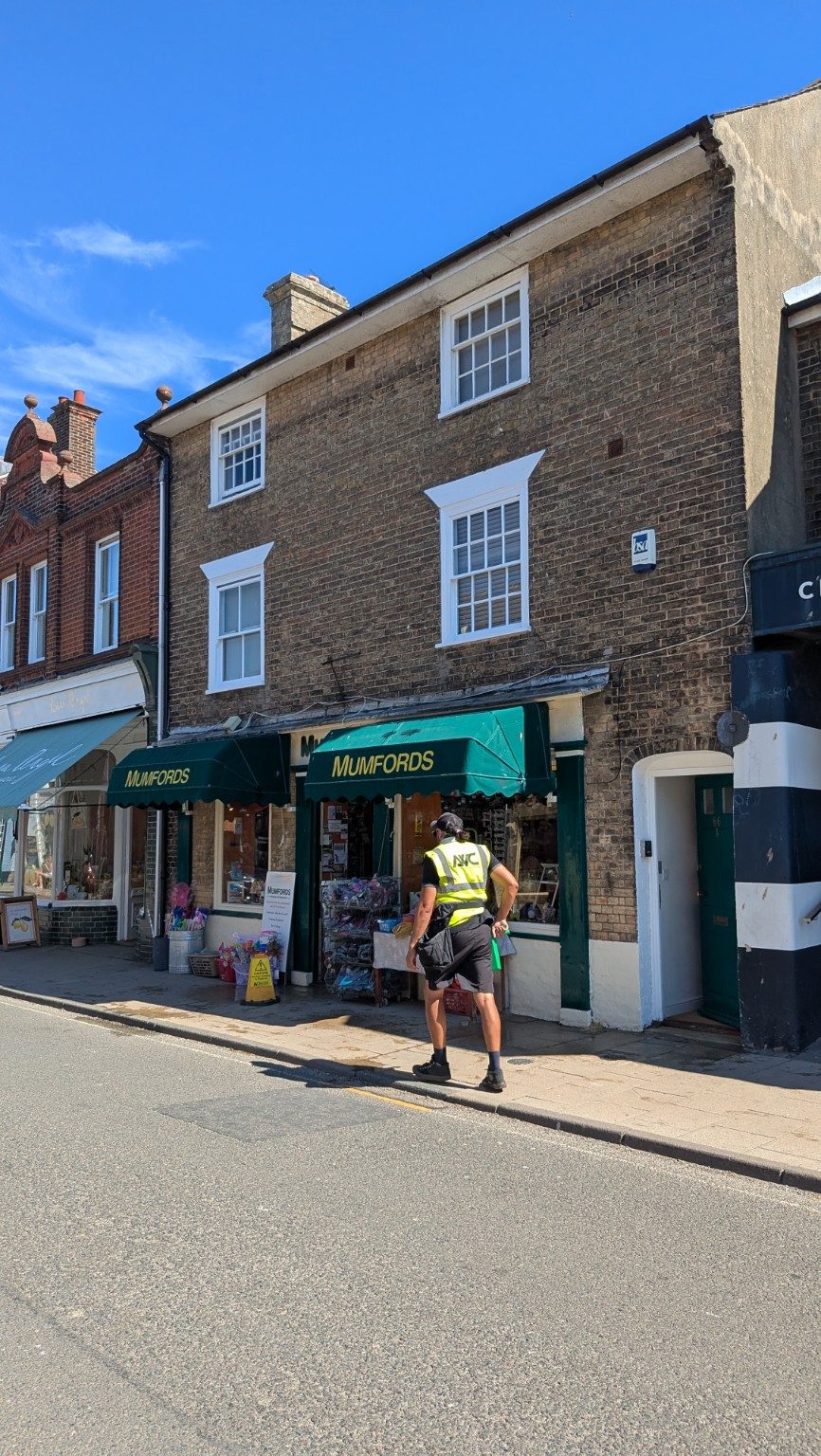 Upper-floor flat window cleaning above a high street business in Southwold